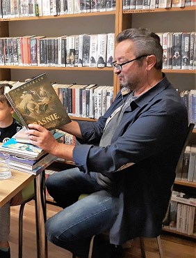 Mieczysław Morański czyta książkę - akcja czytania dzieciom w bibliotece