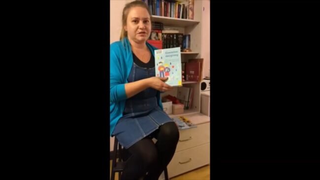 uśmiechnięta bibliotekarka pokazuje omawianą książkę