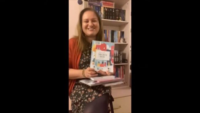 uśmiechnięta bibliotekarka pokazuje omawianą książkę