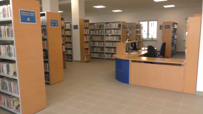 stanowisko bibliotekarzy i regały pełne książek