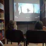 zdjęcie przedstawia dzieci oglądające film na ekranie projektora