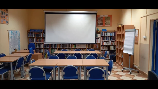 sala biblioteki; stoliki, krzesła, ekran projektora