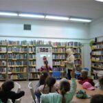 dzieci słuchają bibliotekarki opowiadającej o architekturze