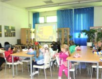 dzieci oglądające prezentację multimedialną na ekranie projektora
