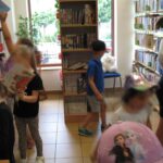 dzieci spacerują po bibliotece i przeglądają książki