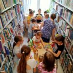 dzieci między regałami bibliotecznymi