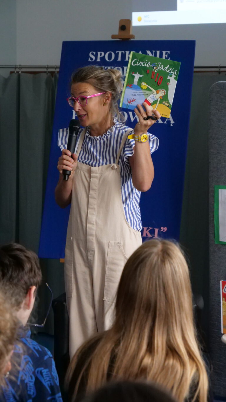 Eliza Piotrowska pokazuje uczniom swoją ksiiążkę 