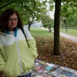 Urszula Wasilewska - autorka projektu pchlego targu w ramach budżetu obywatelskiego - pozuje na tle swojego stoiska z książkami