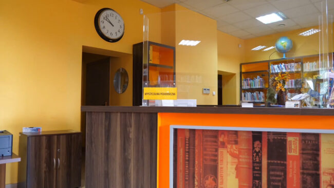 stoisko bibliotekarzy, na ścianie zegar