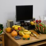 owoce wokół monitora komputera