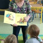 bibliotekarka czyta książkę dzieciom w przedszkolu