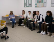 licealiści i aktor siedzą, dyskutując o interpretacji bajki