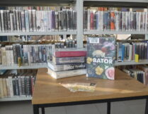 na stoliku w bibliotece jest wyeksponowana książka Joanny Bator pt. "Gorzko, gorzko"; obok są inne książki tej autorki; w tle regały biblioteczne