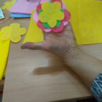 kolorowy kwiat z filcu na dłoni uczestniczki warsztatów