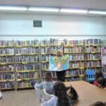 bibliotekarka pokazuje dzieciom dużą mapę