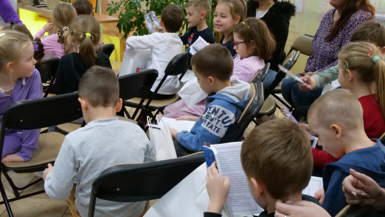 przedszkolaki przeglądają otrzymane upominki książkowe
