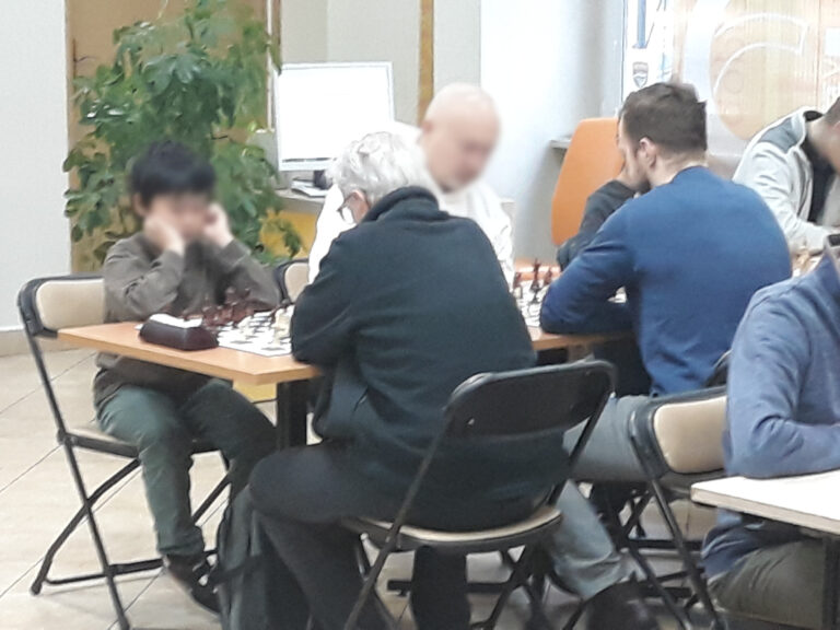 szachiści podczas rozgrywek w sali czytelni naukowej nr 1; chłopiec gra z seniorem