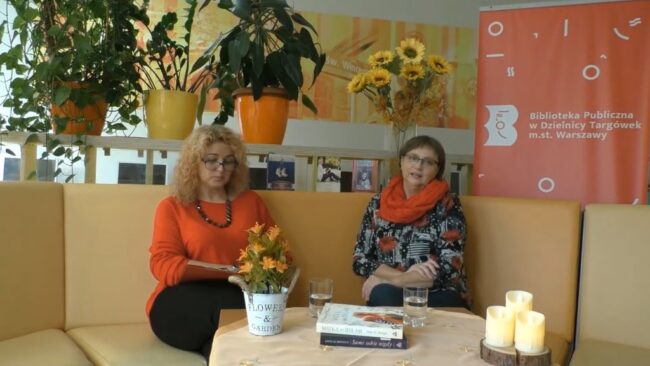na sofie siedzą: pisarka Anna M. Brengos i bibliotekarka; rozmawiają o twórczości Anny M. Brengos