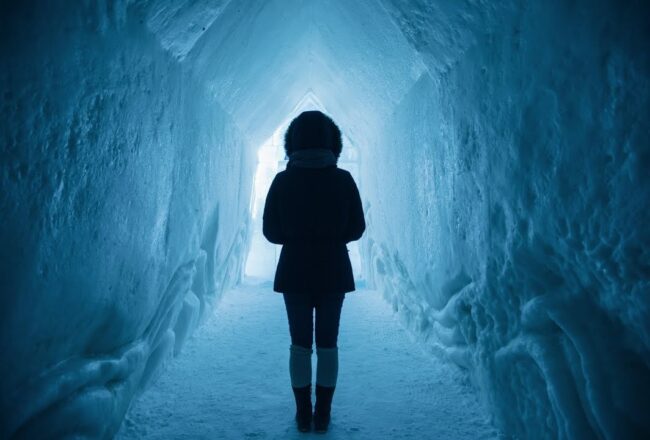 człowiek stoi w tunelu stworzonym z lodu