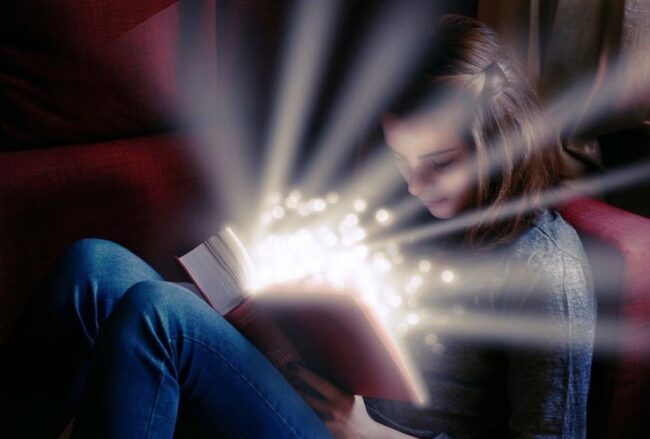 dziewczynka czyta książkę, z której promienieje światłość