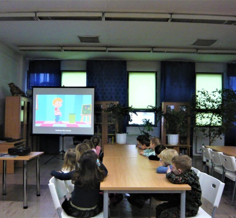 dzieci oglądają prezentację multimedialną o dobrych manierach