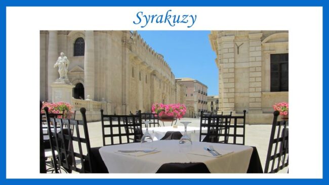 plenerowy stolik kawiarni przy pustym placu, z widokiem na zabytkowe budowle