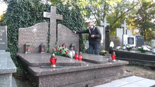 Krzysztof Gajda opowiada o cmentarzu, stojąc przy jednym z grobów