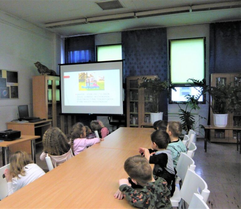 dzieci oglądają prezentację multimedialną o dobrych manierach