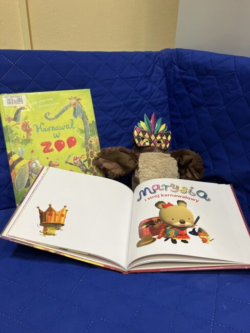 maskotka sowa Jadwiga razem z książką na sofie