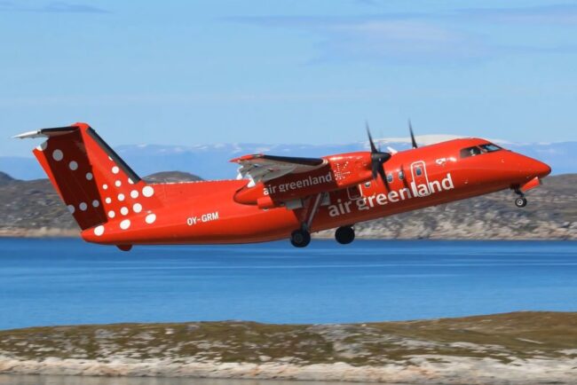 samolot linii Air Greenland tuż nad ziemią, w tle woda i góry