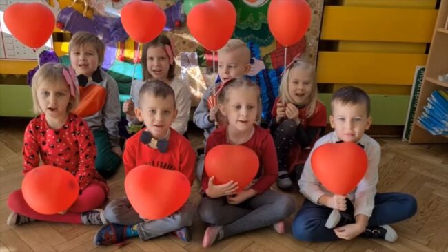grupa dzieci z przedszkola z Serduszkiem przy ul. Bazyliańskiej; dzieci trzymają balony w kształcie serca
