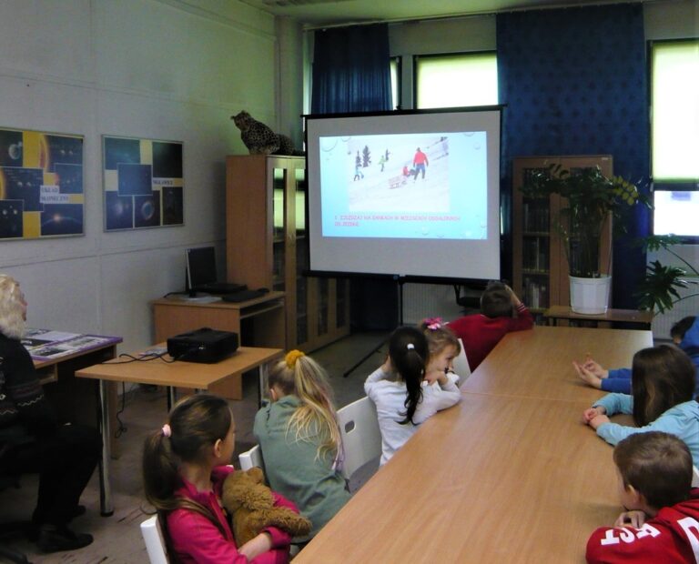 dzieci oglądają na ekranie projektora prezentację multimedialną