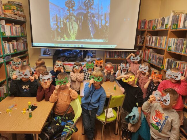 dzieci pokazują stworzone przez siebie maski karnawałowe