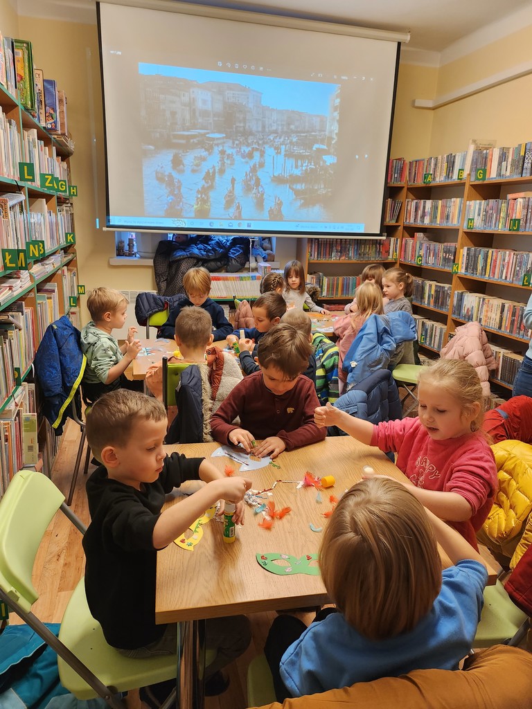 dzieci tworzą maski karnawałowe na zajęciach w bibliotece
