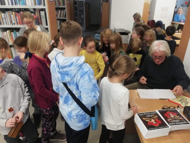 Marek Samselski podpisuje swoją książkę Bajki pana Anagrama i wpisuje dedykacje