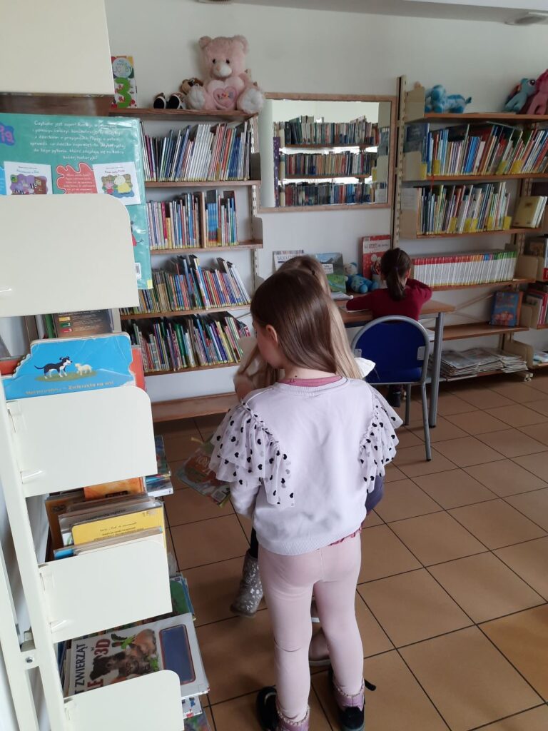Przedszkolaki przeglądające książki.