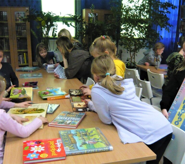 dzieci przeglądają książki w bibliotece