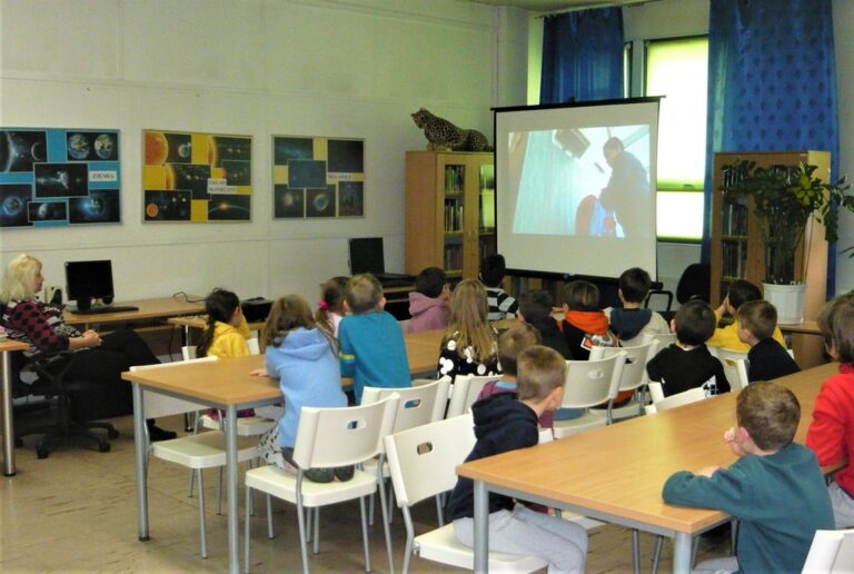 dzieci oglądają prezentację multimedialną na ekranie projektora