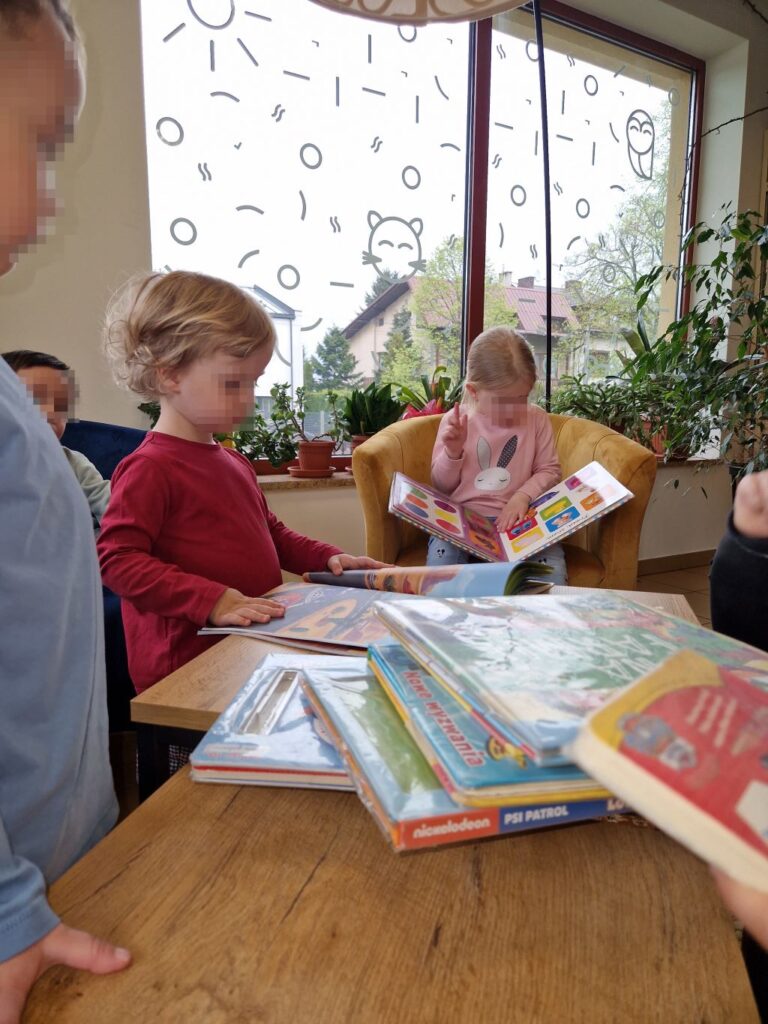 dzieci przeglądają książki w bibliotece