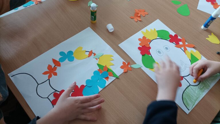 obrazki dzieci - głowy ludzi ozdobione kolorowymi papierowymi kwiatkami