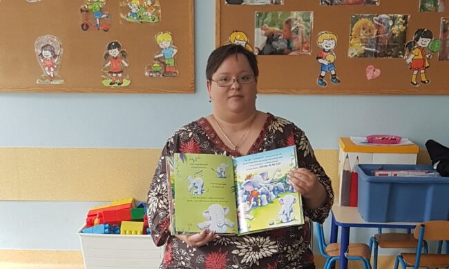 bibliotekarka pokazuje dzieciom obrazki w książce