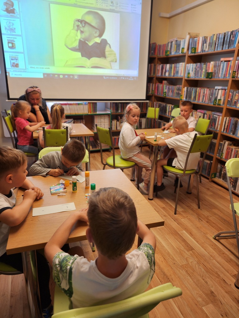 dzieci oglądają w bibliotece prezentację multimedialną o rodzinie