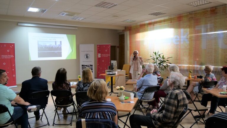 kilkadziesiąt osób na sali słucha prezentacji wspomnieniowej o Janie Pohoskim