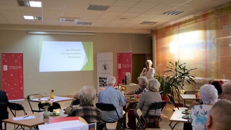 kilkadziesiąt osób na sali słucha prezentacji wspomnieniowej o Janie Pohoskim