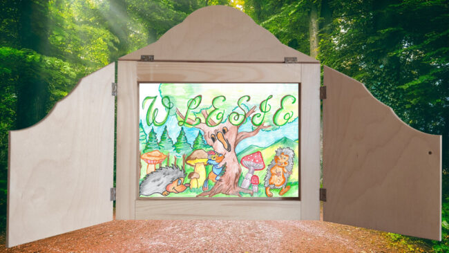 skrzynka japońskiego teatru kamishibai, w środku obrazek tytułowy bajki w lesie; w tle zdjęcie rozsłonecznionego lasu