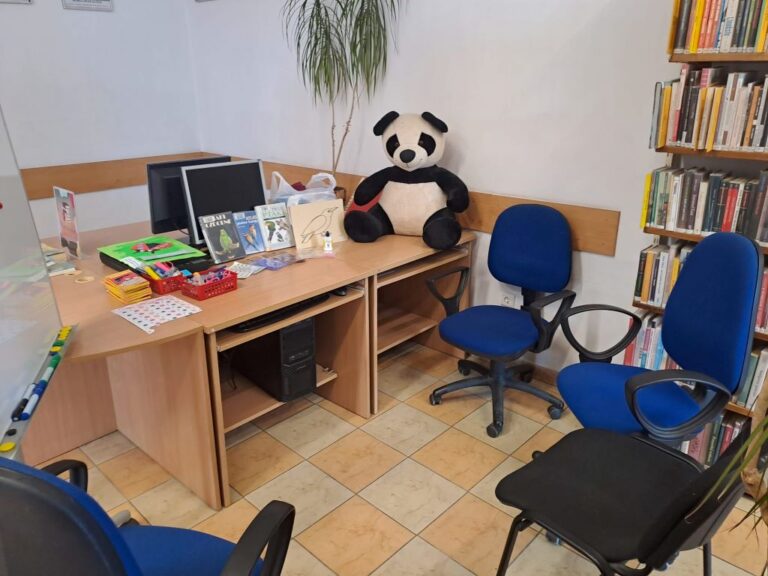 na biurku duża maskotka pandy i książki dla dzieci
