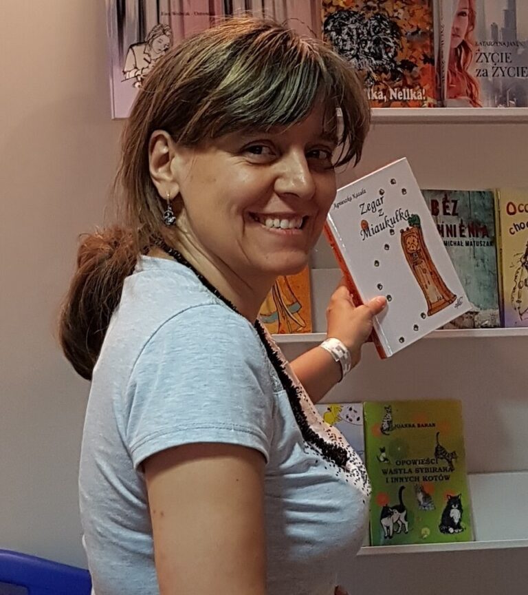 uśmiechnięta pisarka Agnieszka Kazała trzyma swoją książkę