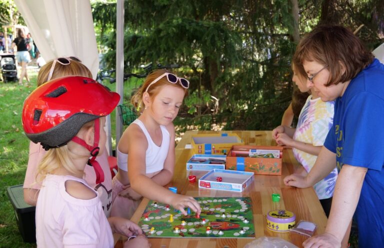 dziewczynki grają w grę planszową z bibliotekarką