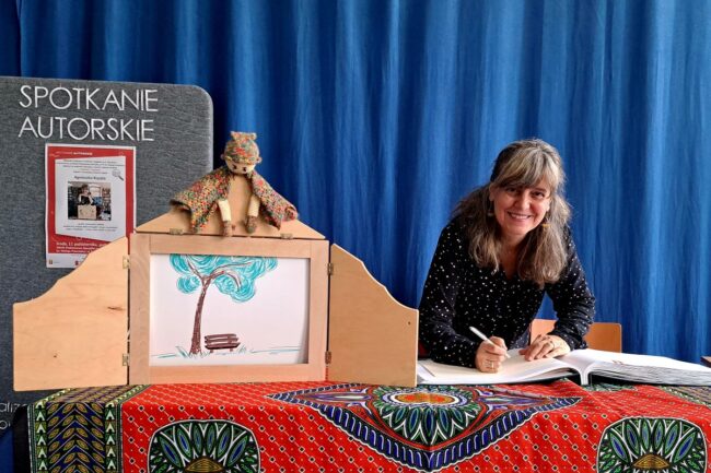 Autorka wpisuje się do księgi pamiątkowej Szkoły.