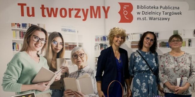 załoga biblioteki pozuje do zdjęcia przy ściance z napisem TworzyMY razem